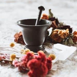 wrought iron mortar and pestle surrounded by flowers